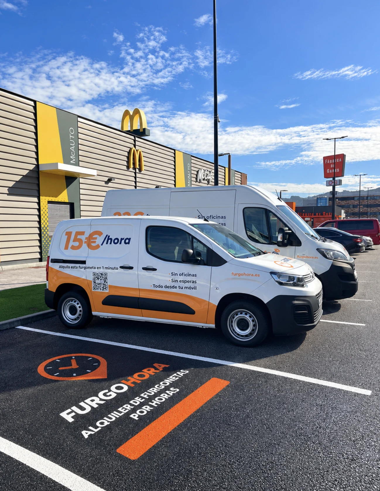 Dos furgonetas de FurgoHora aparcadas en sus plazas señalizadas del Punto FurgoHora Nigrán, junto al McDonald's del parque comercial As Nasas